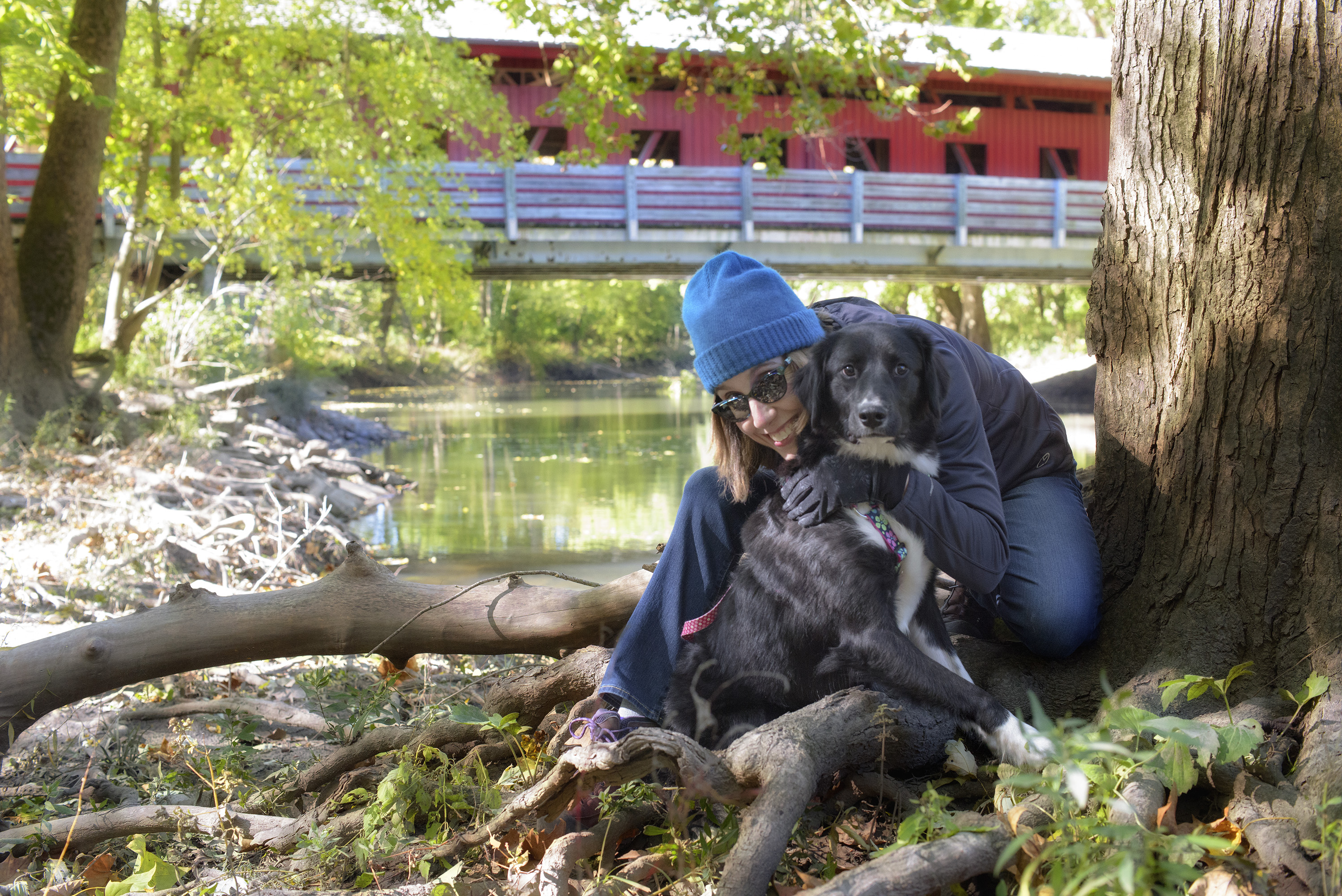 Melissa Cadlwell Woman outside in fall with dog